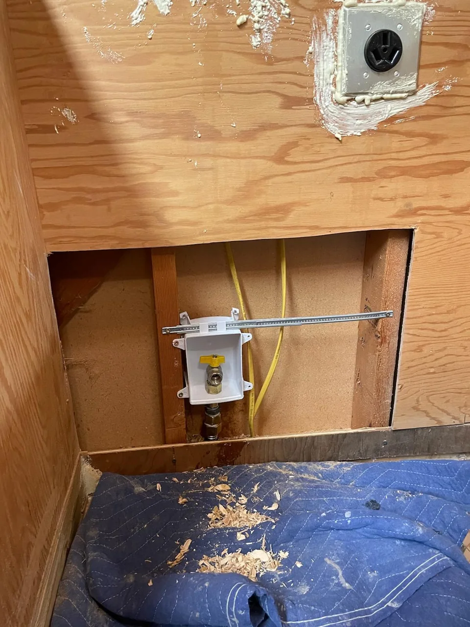 Recessed yellow-handled shutoff valve in an open wall cavity