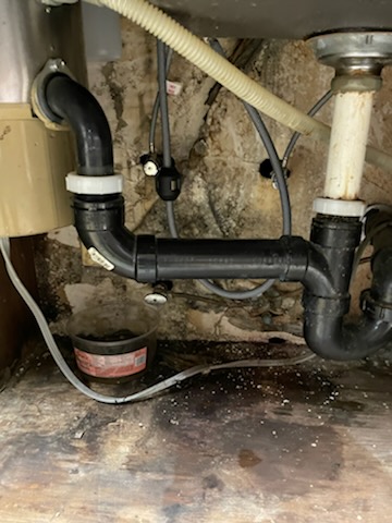 Drain pipes and supply hoses inside a sink cabinet